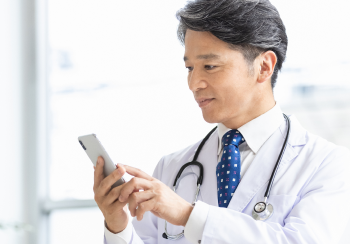 男性医師がスマートフォンを操作している様子