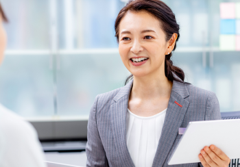 スーツを着た女性が笑顔で面談をしている様子