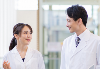 白衣を着た男性と女性の医師が会話をしている様子