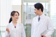 白衣を着た男性と女性の医師が会話をしている様子